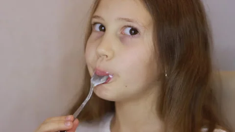 A child eats a curd dessert closeup. A little girl is eating yogurt, dairy produ Stock Footage 256766412