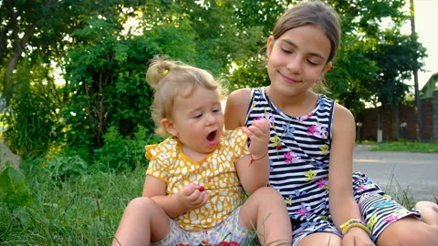 The child eats different berries in the garden. Selective focus. Stock Footage 220082473
