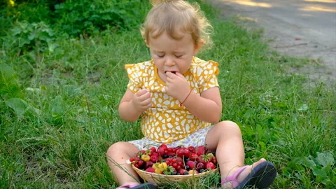 The child eats different berries in the garden. Selective focus. Stock Footage 230302427