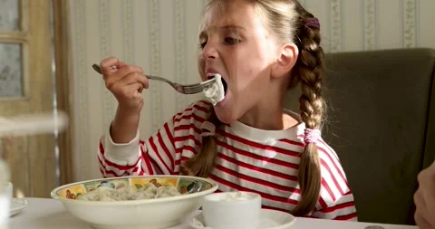 Child eats dumplings sitting at the table at home Stock Footage 262331656