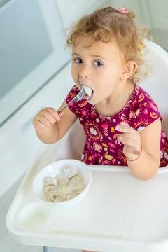 The child eats dumplings at the table. Selective focus. Stock Photos