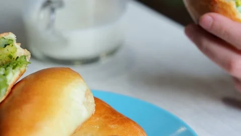 The child eats a freshly baked pie and drinks milk. Stock Footage 229762702