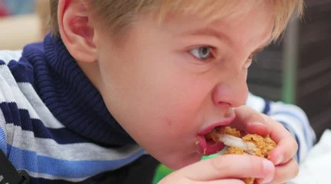 Child eats fried chicken in a fast food restaurant closeup Video stock 68916051