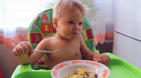 The child eats on a high chair Video stock 64713495