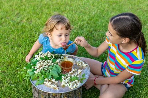 The child eats honey in the garden. Selective focus. Stock Photos