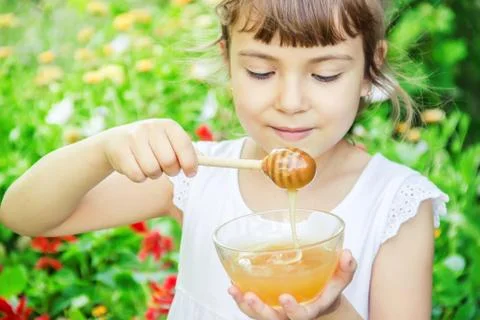The child eats honey. Selective focus. nature. Foto stock