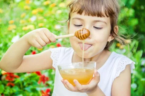 The child eats honey. Selective focus. nature. Foto stock