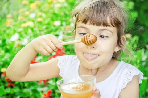 The child eats honey. Selective focus. nature. Stock Photos