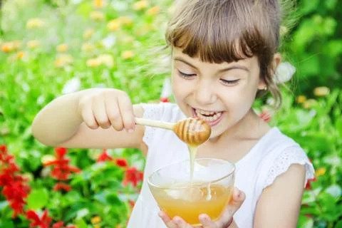 The child eats honey. Selective focus. nature. Foto stock