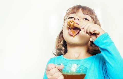 The child eats honey. Selective focus. nature. Stock Photos