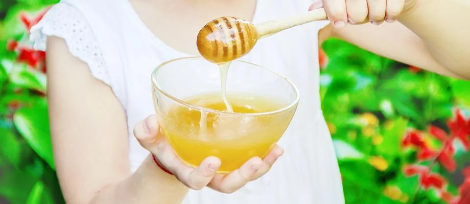 The child eats honey. Selective focus. nature Stock Photos