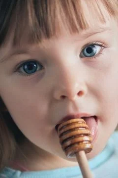 The child eats honey. Selective focus. Stock Photos