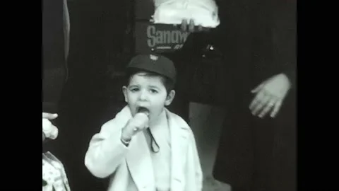 Child eats ice cream in the street in black and white in the 60's Video stock 213542247