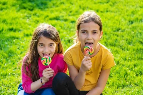 A child eats a lollipop in the park. Selective focus. Stock Photos