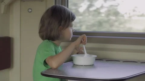 A child eats lunch sitting in a train compartment while traveling Stock Footage 161166723