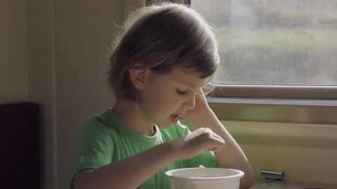 A child eats lunch sitting in a train compartment while traveling Stock Footage 161407783