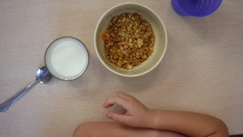 The child eats muesli with milk. Above view. Stock-Footage 100878857