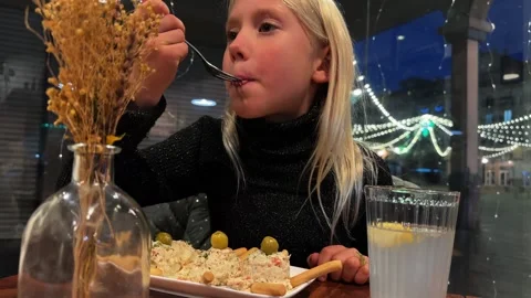 Child eats olivier salad in cafe Stock Footage 303426884