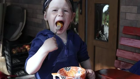The child eats an orange and have fun. Video stock 239359532