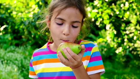 The child eats a pear in the garden. Selective focus. Stock Footage 159748259