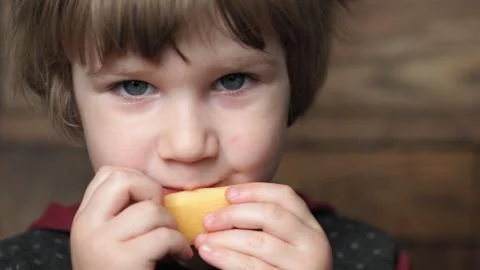 A child eats a piece of cheese Stock Photos