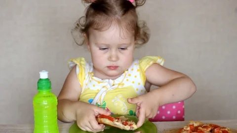 The child eats pizza and drinks lemonade. Cafe and fast food. Stock Footage 78060167
