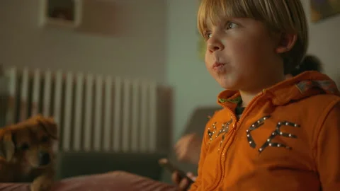 A child eats popcorn while watching tv Stock Footage 146309767