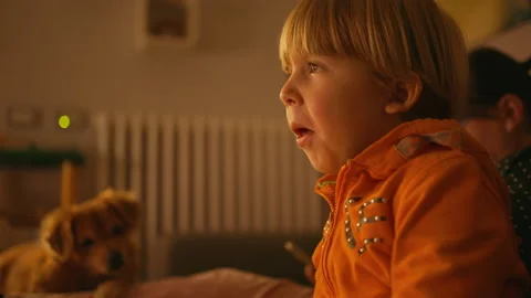 A child eats popcorn while watching tv Stock Footage 146309840
