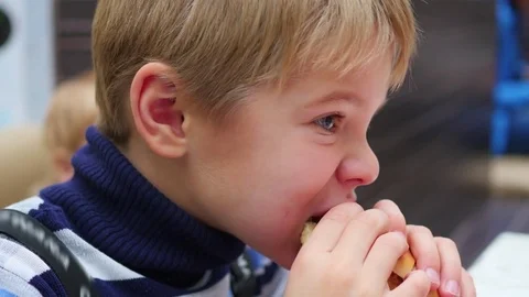 The child eats a scone with chicken in the fast food restaurant 库存影片 70130622