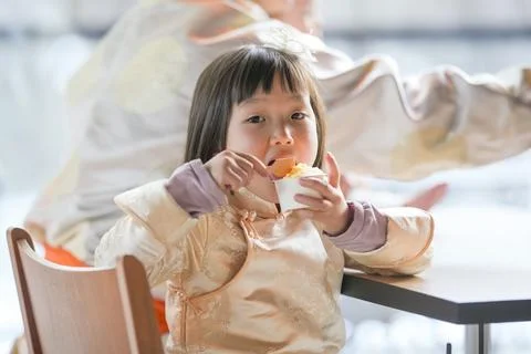Child eats snack at small table Stock Photos