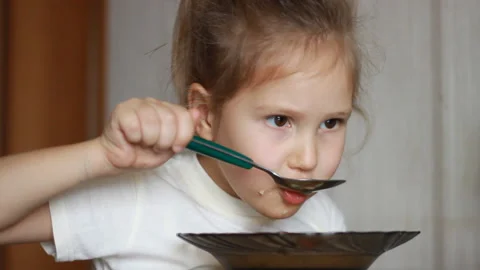 Child eats soup with a spoon Video stock 120730993