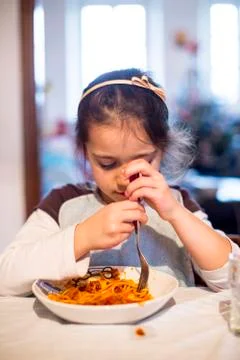 Child eats spaghetti at home in the kitchen Stock Photos