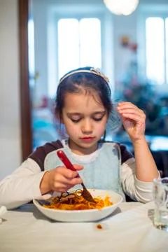 Child eats spaghetti at home in the kitchen Stock Photos