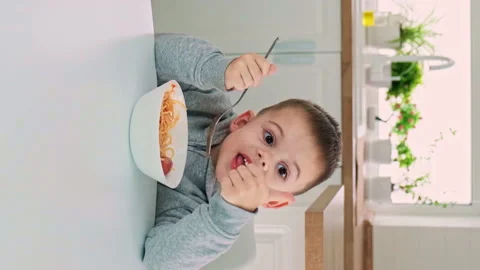The child eats spaghetti in the kitchen. Selective focus. Stock Footage 170820765