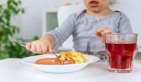 The child eats spaghetti lunch. Selective focus. Stock Photos