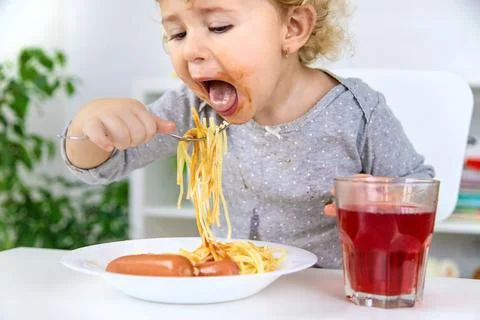 The child eats spaghetti lunch. Selective focus. Stock Photos