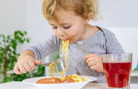 The child eats spaghetti lunch. Selective focus. Stock Photos
