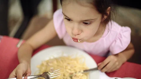Child eats spaghetti pasta in the restaurant which is located on the shore Stock Footage 39830820