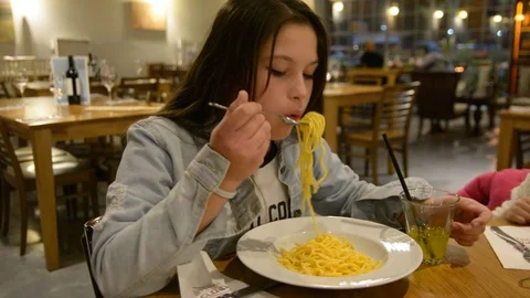 Child eats spaghetti pasta in the restaurant. Low light selective focus. Stock Footage 101665000