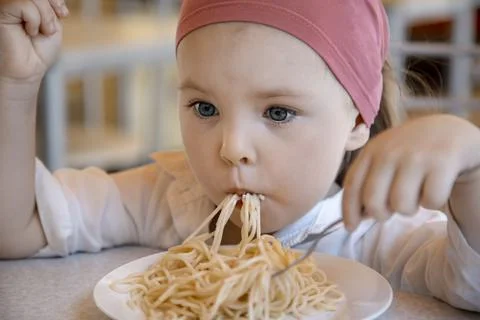 The child eats spaghetti. Stock Photos