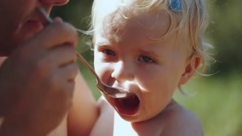The child eats with a spoon in the hands of the pope Stock Footage 209161687
