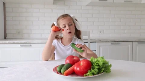 The child eats vegetables with joy and pleasure. a little girl dines in the Stock Footage 138987783