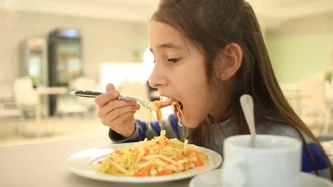 The child eats a vegetarian cabbage salad in a restaurant Stock Footage 76590011