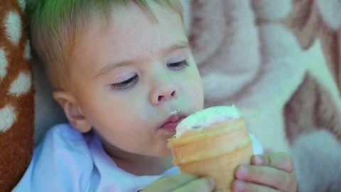 The child eats a waffle cup ice cream at closeup Vidéo 76320262