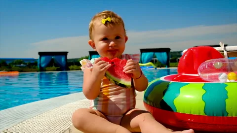 The child eats a watermelon near the pool. Selective focus. Stock Footage 165060268