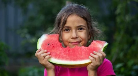 A child eats a watermelon. Selective focus. Stock Photos