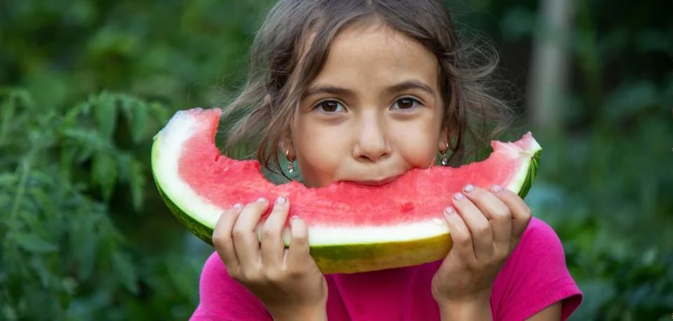 A child eats a watermelon. Selective focus. Stock Photos