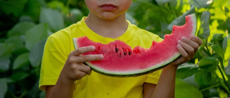A child eats a watermelon. Selective focus. Stock Photos