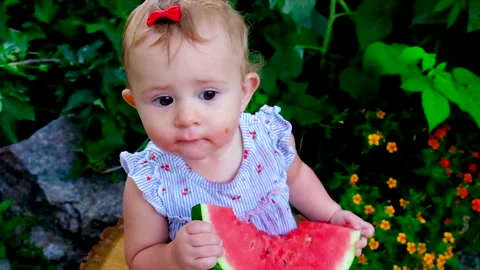 A child eats a watermelon on the street. Selective focus. Stock Footage 164835309