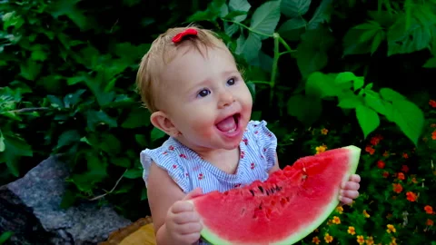 A child eats a watermelon on the street. Selective focus. Stock Footage 165040496